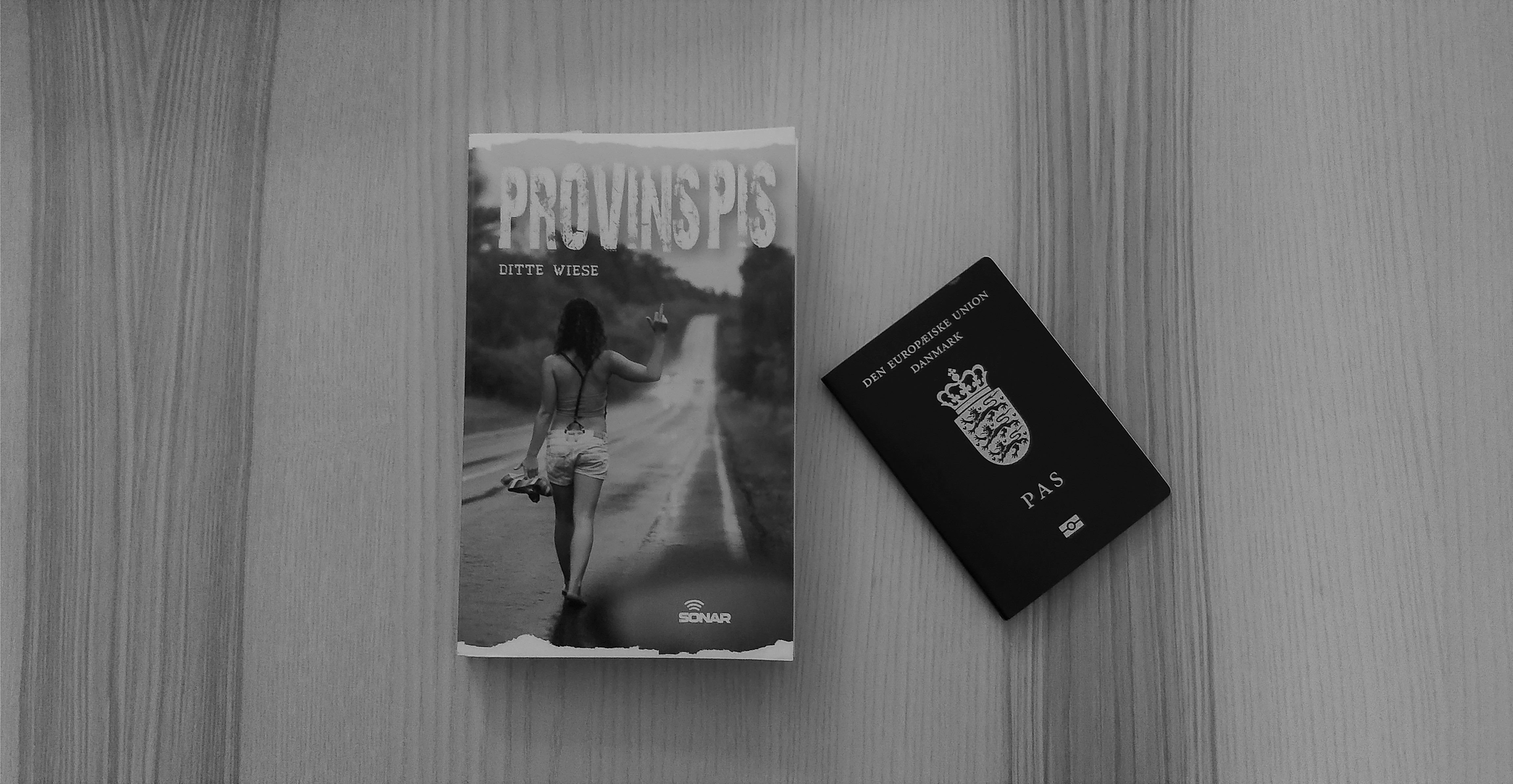 The book Provinspis on a table next to a passport.