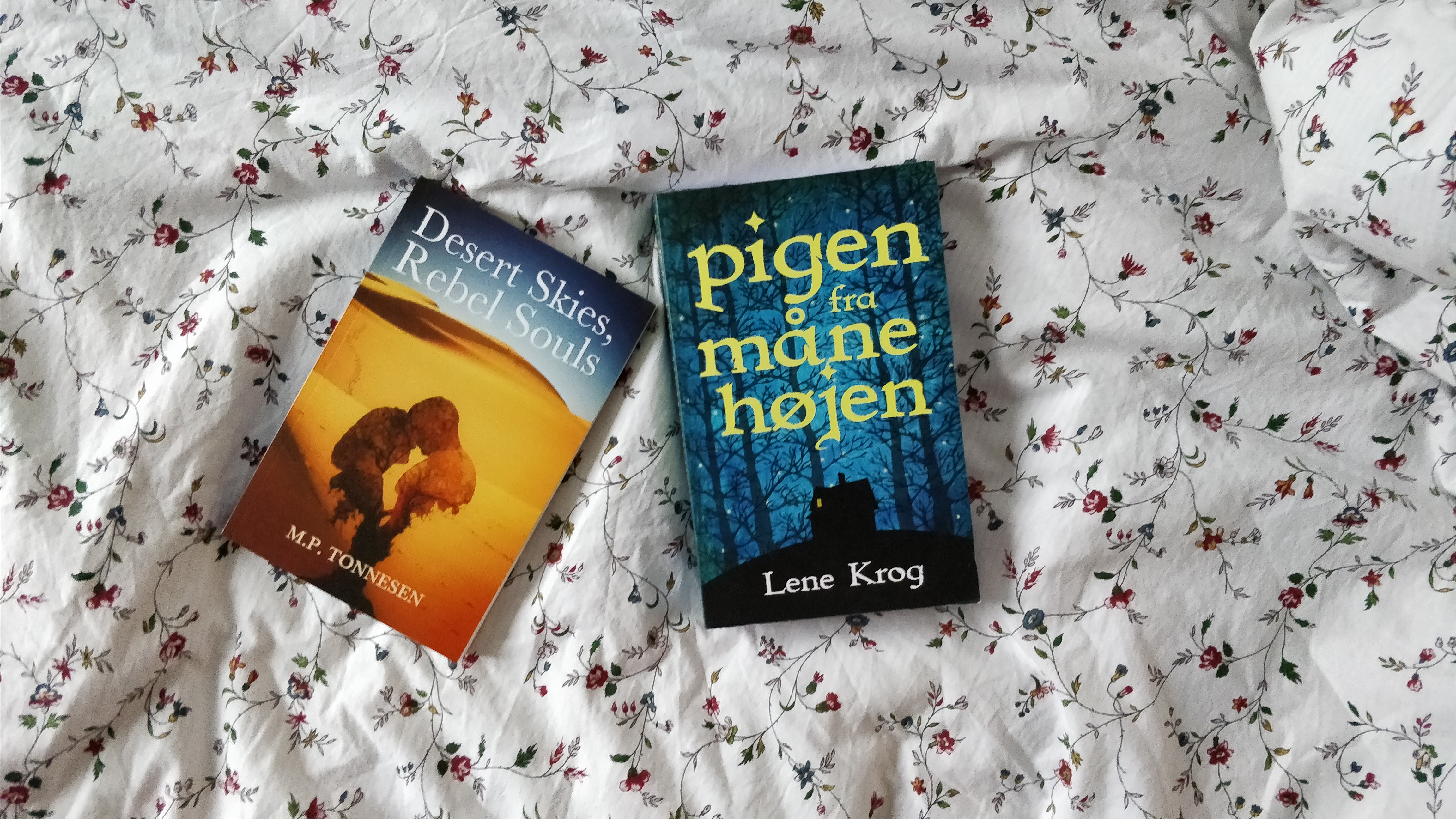 The books Desert Skies, Rebel Souls and Pigen fra Månehøjen on a flowery background.